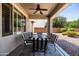 This covered patio offers a ceiling fan and dining furniture for al fresco eating at 21030 E Misty Ln, Queen Creek, AZ 85142