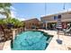 Sparkling pool with stone waterfall feature, surrounded by ample patio space and lush greenery at 21030 E Misty Ln, Queen Creek, AZ 85142