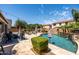 Lush backyard featuring a pool with rock waterfall, ample seating, and mature landscaping, perfect for entertaining at 21030 E Misty Ln, Queen Creek, AZ 85142