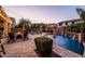 Stunning backyard featuring a beautiful pool, lush landscaping, and a cozy fire pit, ideal for outdoor gatherings at 21030 E Misty Ln, Queen Creek, AZ 85142
