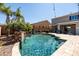 Inviting backyard pool featuring a stone waterfall, lush landscaping, and a relaxing outdoor lounge area at 21030 E Misty Ln, Queen Creek, AZ 85142
