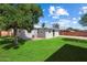 Backyard featuring a well-maintained lawn, a brick patio, and mature trees at 2321 W Claremont St, Phoenix, AZ 85015