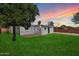 Large backyard featuring lush green grass, mature trees, a brick patio, and partial privacy fence at 2321 W Claremont St, Phoenix, AZ 85015