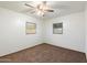 Bright bedroom featuring neutral paint, ceiling fan, and two windows providing natural light at 2321 W Claremont St, Phoenix, AZ 85015