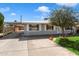 Single-story home featuring a long driveway, and a well-maintained front yard at 2321 W Claremont St, Phoenix, AZ 85015