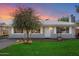 Charming single-story home featuring a well-manicured lawn, brick accents, and a mature shade tree at 2321 W Claremont St, Phoenix, AZ 85015