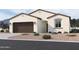 Charming stucco home with a well-maintained lawn, a two-car garage, and desert landscaping at 24090 W Sunland Ave, Buckeye, AZ 85326