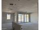 Expansive living room with unfinished walls, wiring visible, and sliding glass doors to backyard at 24090 W Sunland Ave, Buckeye, AZ 85326