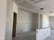 Bright living room with unfinished walls, wiring visible, and a smooth, unpainted ceiling at 24090 W Sunland Ave, Buckeye, AZ 85326
