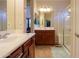 Bathroom featuring dual sinks, wooden cabinets, tile flooring, and a glass-enclosed shower at 2480 E Hancock Trl, Casa Grande, AZ 85194