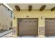 Two-car garage with carriage style doors, stone accents, and decorative beams at 2725 E Mine Creek Rd # 2186, Phoenix, AZ 85024