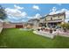 An amazing backyard with artificial turf, a pool with a rock waterfall, a covered patio, and a built-in fire pit at 29437 W Columbus Ave, Buckeye, AZ 85396