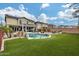 Expansive backyard featuring a sparkling pool, lush grass, and a built-in fire pit, ideal for outdoor activities at 29437 W Columbus Ave, Buckeye, AZ 85396