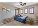 Cozy bedroom features natural light with plantation shutters and a classic ceiling fan at 29437 W Columbus Ave, Buckeye, AZ 85396