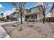 Two-story home featuring a two-car garage and low-maintenance desert landscaping with mature trees and rocks at 29437 W Columbus Ave, Buckeye, AZ 85396