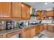 Well-equipped kitchen featuring granite countertops, a gas cooktop, and wood cabinetry at 29437 W Columbus Ave, Buckeye, AZ 85396
