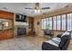 Cozy living room with stone fireplace, built-in cabinets, and a ceiling fan at 29437 W Columbus Ave, Buckeye, AZ 85396
