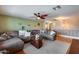 Open concept living room with comfortable seating, hardwood floors, ceiling fan and neutral colors at 29437 W Columbus Ave, Buckeye, AZ 85396