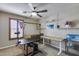 Room featuring ceiling fan, wall shelves, plantation shutters, and multiple work surfaces at 29437 W Columbus Ave, Buckeye, AZ 85396