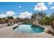 Beautiful swimming pool with rock features and lush landscaping, creating a private and serene backyard retreat at 29437 W Columbus Ave, Buckeye, AZ 85396