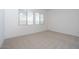 Well-lit bedroom with neutral carpet, baseboards, and large window at 338 E Las Perlas Ln, San Tan Valley, AZ 85140