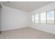 Bright bedroom featuring neutral carpet and multiple large windows at 338 E Las Perlas Ln, San Tan Valley, AZ 85140