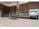 Close up of a modern kitchen featuring dark cabinets, stainless appliances, quartz countertops, and tile backsplash at 338 E Las Perlas Ln, San Tan Valley, AZ 85140