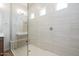 Bright shower featuring tiled walls, glass enclosure and a shower seat at 338 E Las Perlas Ln, San Tan Valley, AZ 85140
