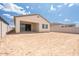 Backyard view with a covered patio, and a beige stucco house under a blue sky at 352 E Las Perlas Ln, San Tan Valley, AZ 85140