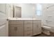 Well-lit bathroom with double vanity, warm wood-look floors, and a bright white tub/shower at 352 E Las Perlas Ln, San Tan Valley, AZ 85140