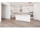 Bright, modern kitchen with white cabinets, stainless steel appliances, a large island and light wood-look flooring at 352 E Las Perlas Ln, San Tan Valley, AZ 85140