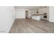Open-concept living room and kitchen with wood-look tile flooring, recessed lighting, and abundant natural light at 352 E Las Perlas Ln, San Tan Valley, AZ 85140