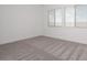 A bright bedroom features white walls, neutral carpet, and a view from the window at 366 E Las Perlas Ln, San Tan Valley, AZ 85140