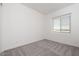 This bedroom features carpet flooring, neutral paint, and large window at 366 E Las Perlas Ln, San Tan Valley, AZ 85140