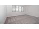 A sunlit bedroom with gray carpet and bright white walls with a window that gives great natural light at 366 E Las Perlas Ln, San Tan Valley, AZ 85140