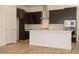 Modern kitchen with dark cabinets, stainless steel appliances, a white island, and wood-look floors at 366 E Las Perlas Ln, San Tan Valley, AZ 85140