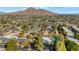 Wide aerial view of neighborhood with mountains in the background, showcasing houses and trees at 37 Spur Cir, Scottsdale, AZ 85251