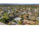 Aerial view of a suburban neighborhood with houses, green trees, and a distant mountain range at 37 Spur Cir, Scottsdale, AZ 85251