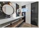 Modern bathroom featuring dual sinks, striking black and white striped walls, and round mirrors at 37 Spur Cir, Scottsdale, AZ 85251