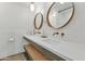 Bathroom with dual sinks, modern fixtures, wood accents, and oval mirrors at 37 Spur Cir, Scottsdale, AZ 85251