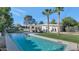 Beautiful backyard pool with palm trees, well-manicured lawn, and a covered patio with stylish seating at 37 Spur Cir, Scottsdale, AZ 85251