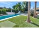 Backyard pool area featuring lush lawn, mature landscaping and a modern lounge area, perfect for entertaining at 37 Spur Cir, Scottsdale, AZ 85251