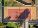 Aerial of tennis court with lighting, surrounded by lush greenery and walking path at 37 Spur Cir, Scottsdale, AZ 85251