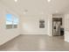 Open living area with tile flooring, white walls, and stainless steel refrigerator at 37098 W Prado St, Maricopa, AZ 85138