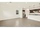 Open living area with tile flooring, stainless steel refrigerator and dark cabinets at 37098 W Prado St, Maricopa, AZ 85138