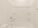 Bright white shower-tub combo featuring a shower head and built-in shelving at 37098 W Prado St, Maricopa, AZ 85138
