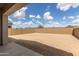 Spacious backyard featuring block wall fencing under a beautiful sky with fluffy white clouds at 3746 E Rochelle Cir, Mesa, AZ 85215