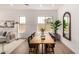 Bright dining space showcasing a wooden table, black chairs, large mirror, and wood look flooring at 3746 E Rochelle Cir, Mesa, AZ 85215