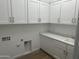 Efficient laundry room with ample storage and a utility sink at 3746 E Rochelle Cir, Mesa, AZ 85215