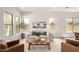 Cozy living area with a comfortable sofa, brown leather chairs, tile floors, and bright windows at 3746 E Rochelle Cir, Mesa, AZ 85215